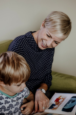 Melanie Watermeyer zeigt einem Jungen ein Therapiebuch